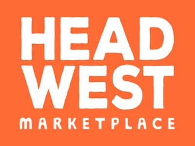The image features a logo on an orange background that reads "HEAD WEST MARKETPLACE" in bold, white typography. The text is stylized with varying upper and lowercase letters, creating a modern and inviting appearance.